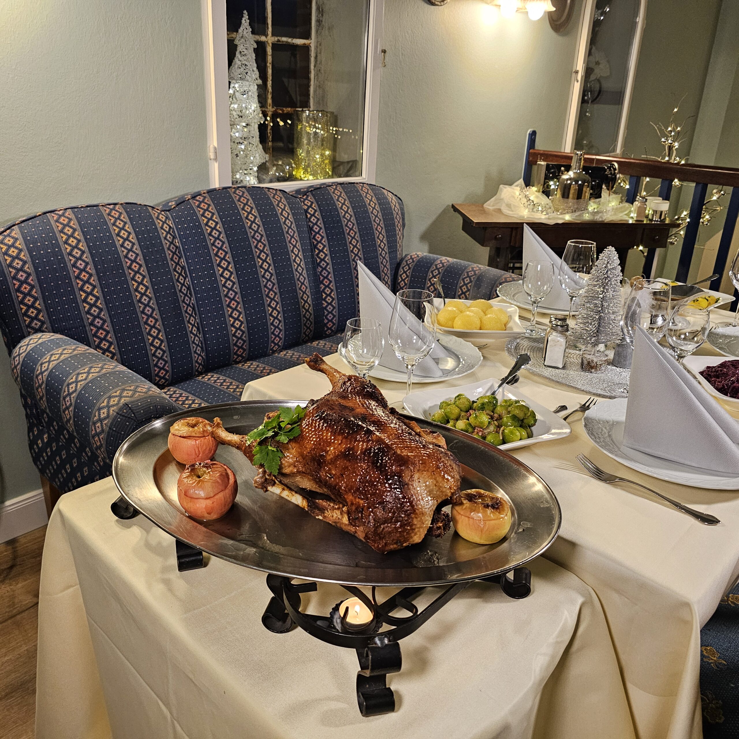 Festlich gedeckter Tisch mit ganzer Gans im gemütlichen Restaurant